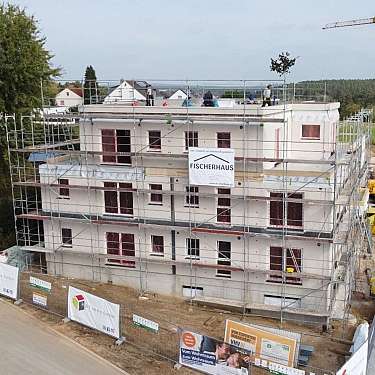 Mehrstöckiges Gebäude im Bau, vollständig von einem Gerüst umgeben.